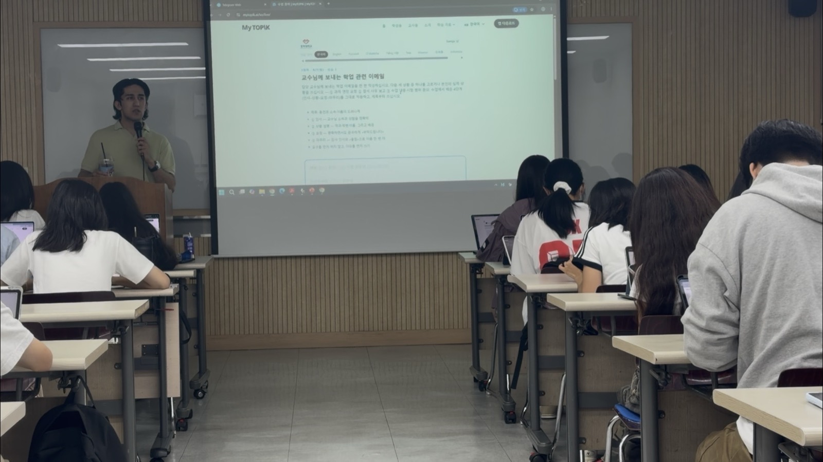 A writing task displayed on the projector, showing the prompt and its checklist